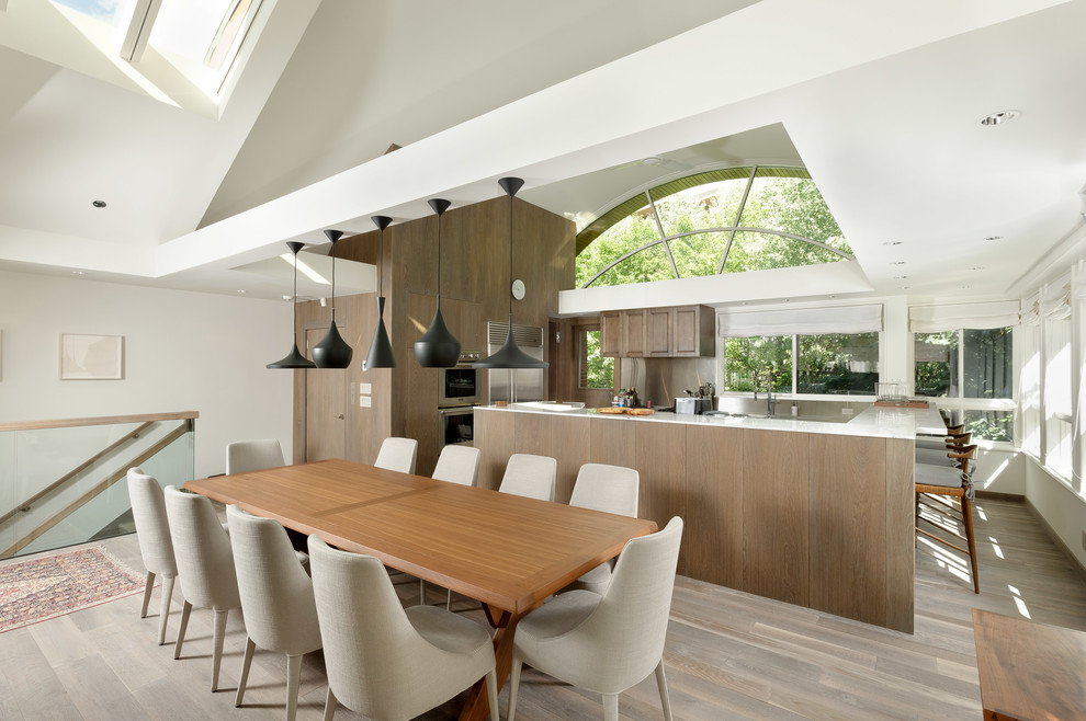 Ispirazione per una sala da pranzo aperta verso la cucina minimal di medie dimensioni con pareti bianche, parquet chiaro e camino bifacciale