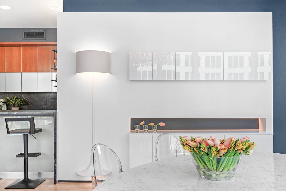 Immagine di una sala da pranzo aperta verso la cucina minimalista di medie dimensioni con pareti con effetto metallico, parquet chiaro, camino sospeso, cornice del camino in mattoni e pavimento beige