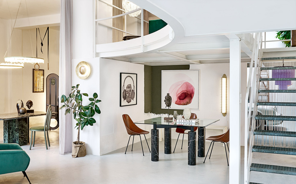 Cette image montre une salle à manger ouverte sur le salon design avec un mur blanc, sol en béton ciré et un sol gris.