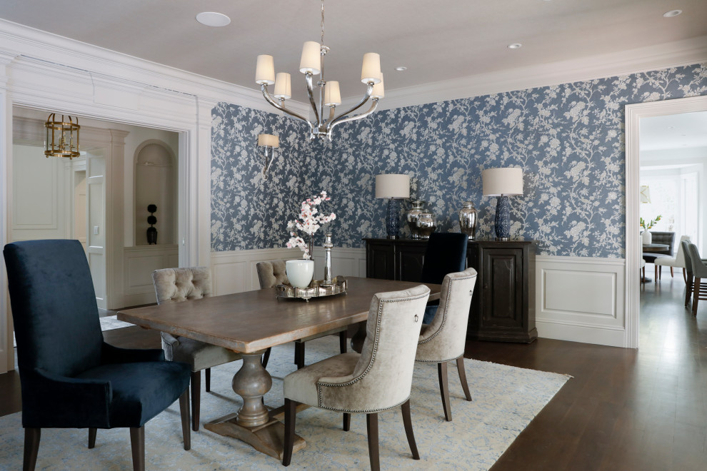 Exemple d'une salle à manger ouverte sur la cuisine chic avec un mur bleu, parquet foncé et boiseries.