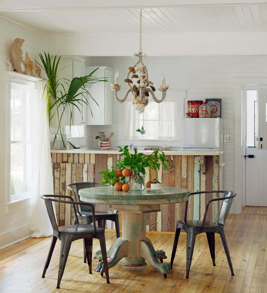 Idee per una sala da pranzo aperta verso la cucina stile marinaro con pareti bianche e pavimento in legno massello medio