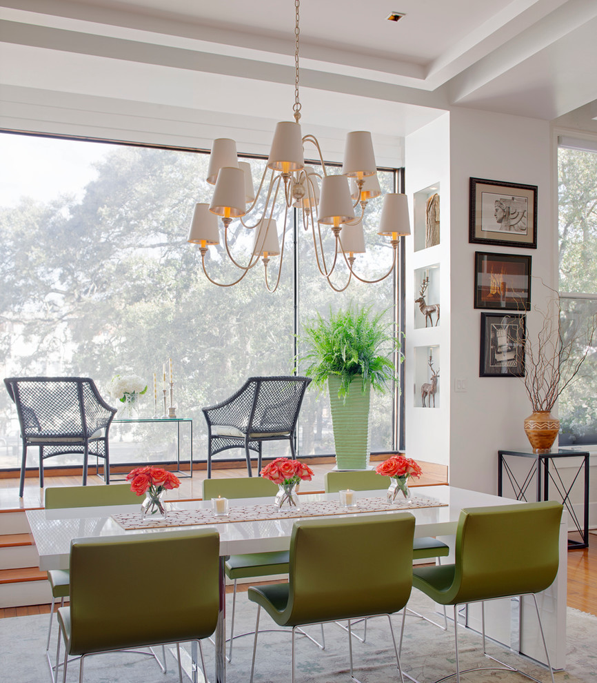 Réalisation d'une salle à manger ouverte sur le salon design avec un mur blanc et un sol en bois brun.