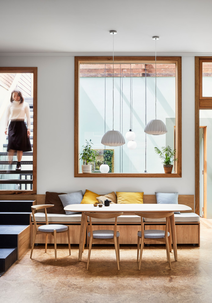 Esempio di una sala da pranzo minimal con pareti bianche e pavimento marrone