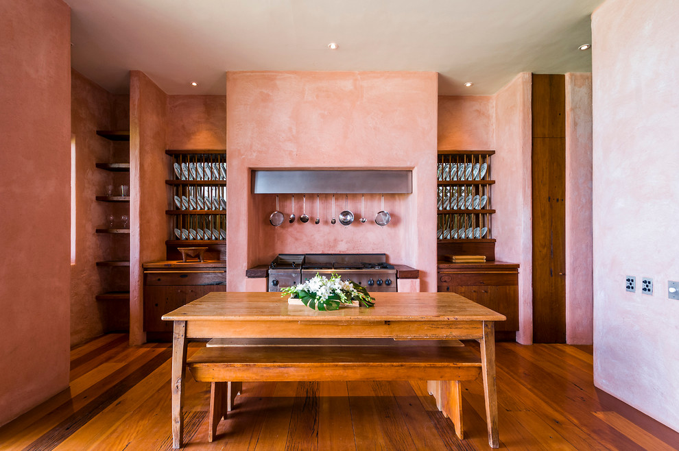 Imagen de comedor bohemio con paredes rosas y suelo de madera en tonos medios