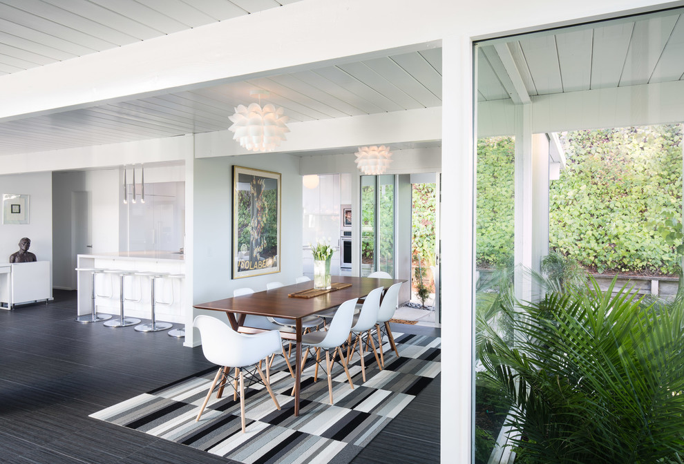 Immagine di una sala da pranzo aperta verso il soggiorno minimalista con pareti bianche