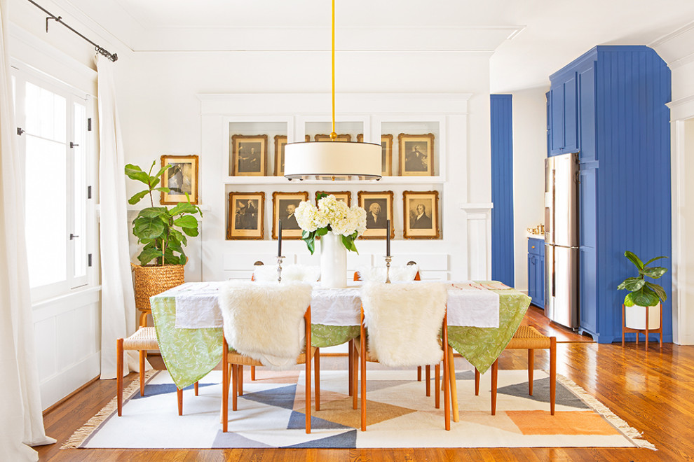 Immagine di una sala da pranzo aperta verso il soggiorno american style di medie dimensioni con pareti bianche, parquet scuro e pavimento marrone