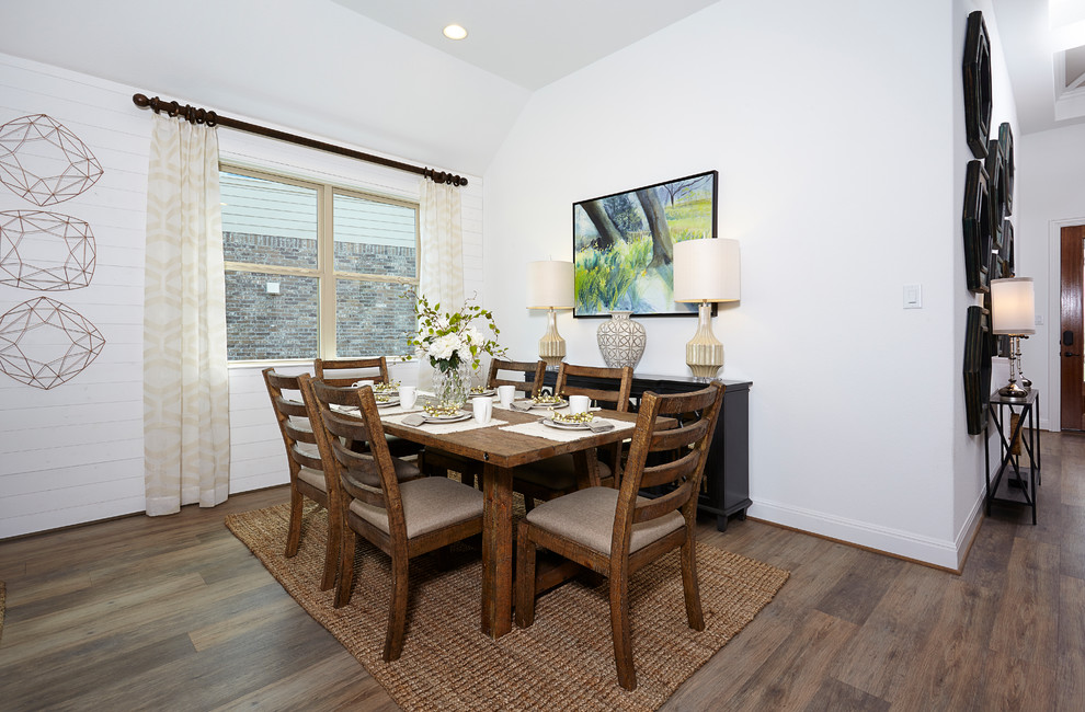 Esempio di una sala da pranzo aperta verso la cucina country di medie dimensioni con pareti bianche, pavimento in legno massello medio e pavimento marrone