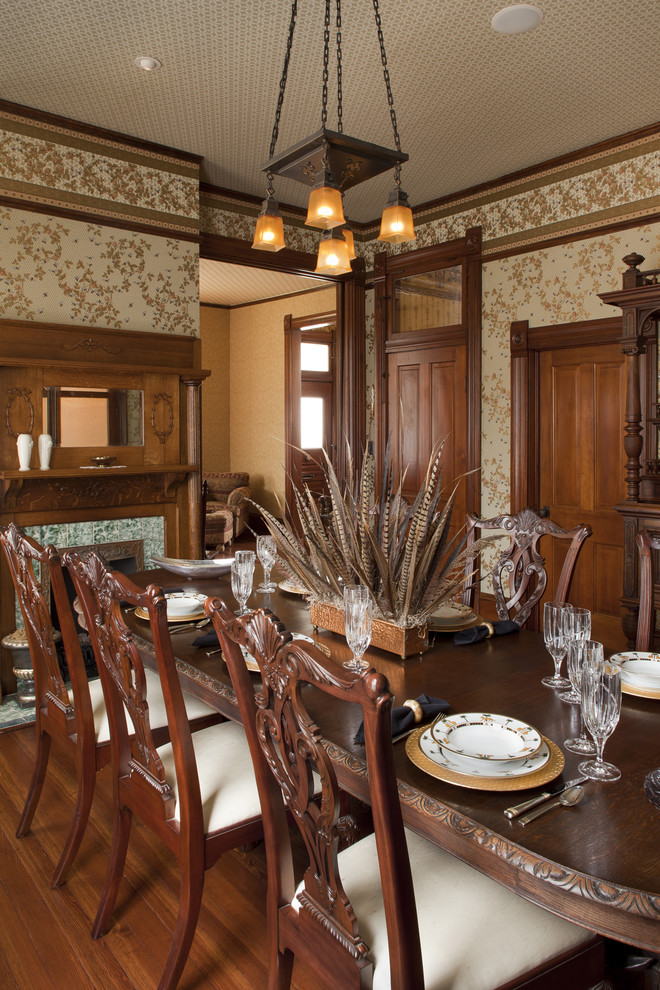 Inspiration for a victorian dark wood floor enclosed dining room remodel in Austin with a standard fireplace