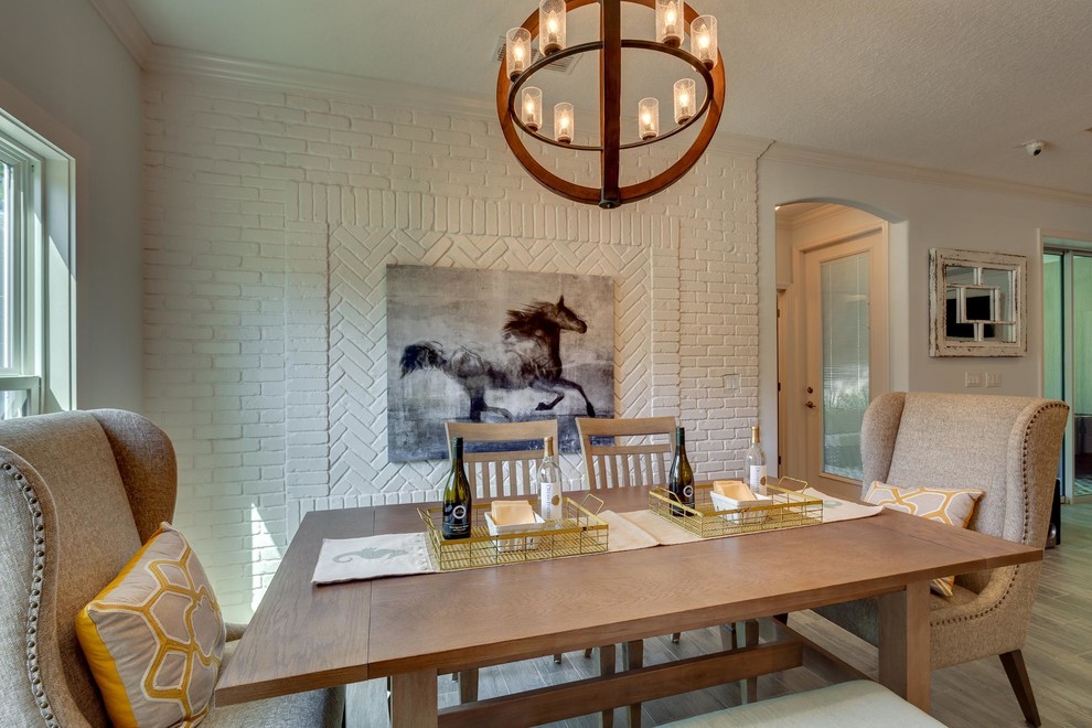 На фото: гостиная-столовая среднего размера в современном стиле с белыми стенами и полом из ламината без камина