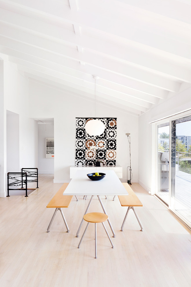 Cette photo montre une salle à manger ouverte sur le salon scandinave avec un mur blanc, parquet clair et éclairage.