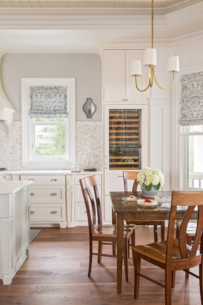 Immagine di una piccola sala da pranzo aperta verso la cucina chic con pareti beige e pavimento in legno massello medio