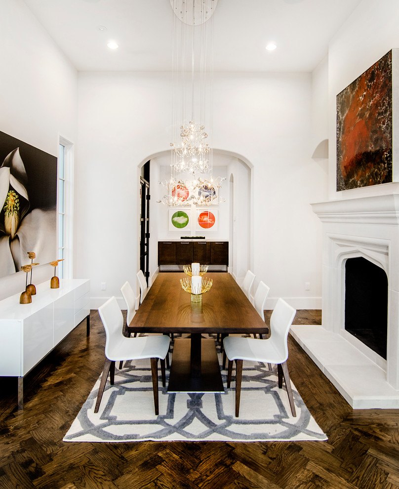 Example of a tuscan dark wood floor dining room design in Dallas with white walls, a standard fireplace and a plaster fireplace