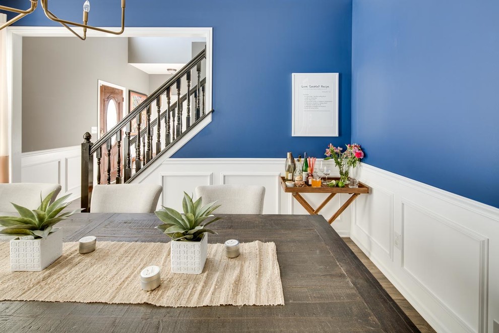 Foto di una sala da pranzo aperta verso la cucina minimal di medie dimensioni con pareti blu e pavimento in legno massello medio