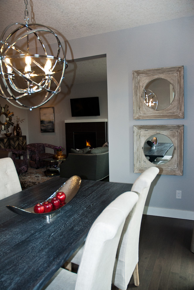 Photo of a medium sized modern open plan dining room in Edmonton with grey walls, medium hardwood flooring, a standard fireplace and a tiled fireplace surround.