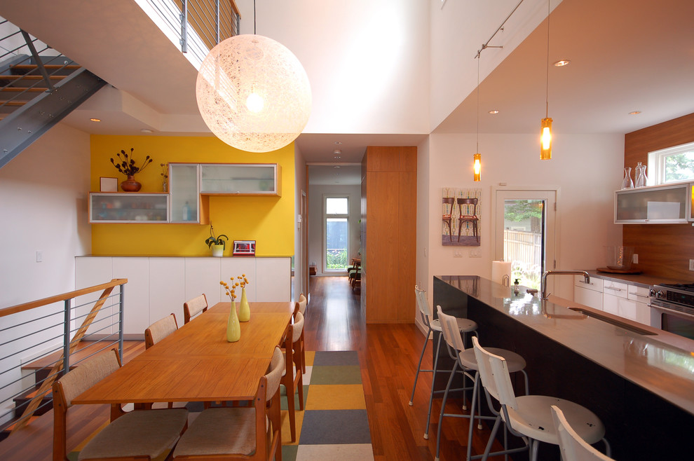 Exempel på ett modernt kök med matplats, med gula väggar och mörkt trägolv