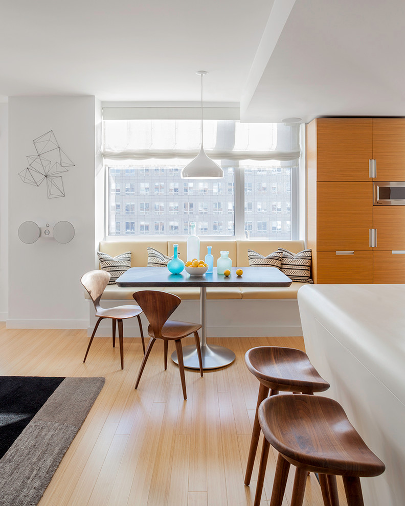 Offenes Modernes Esszimmer mit weißer Wandfarbe und hellem Holzboden in New York