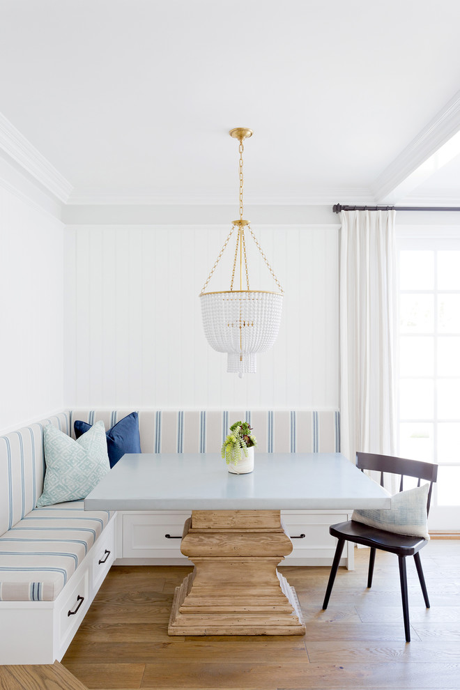 Photo of a nautical dining room in Orange County with white walls and light hardwood flooring.