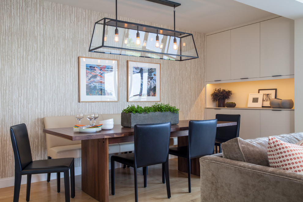 Idee per una sala da pranzo aperta verso il soggiorno chic con pareti beige e pavimento in legno massello medio