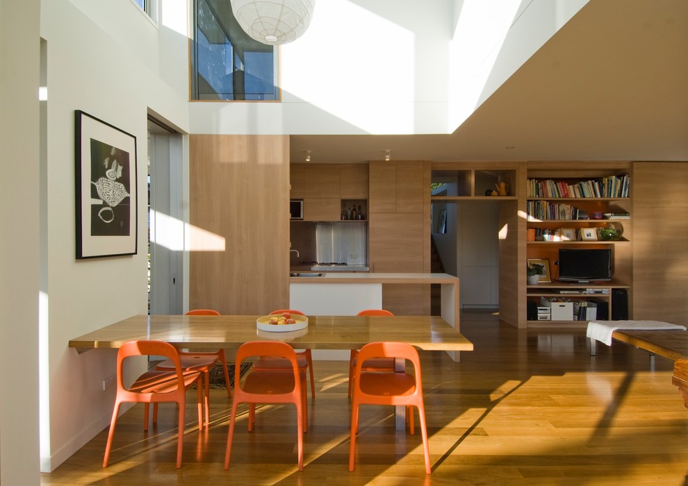 Imagen de comedor de cocina contemporáneo con paredes blancas y suelo de madera en tonos medios