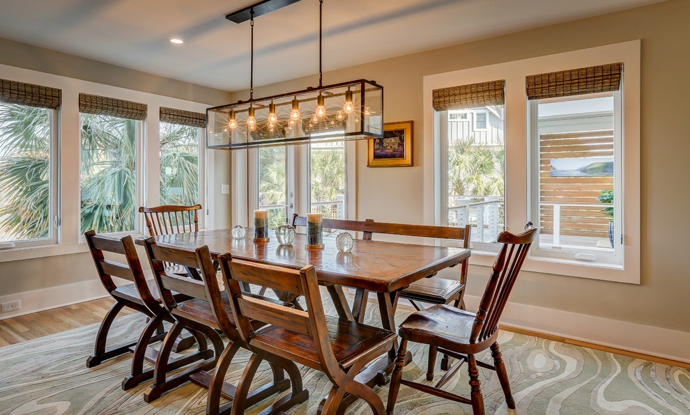 Immagine di una sala da pranzo aperta verso la cucina stile marino di medie dimensioni con pareti beige e parquet chiaro