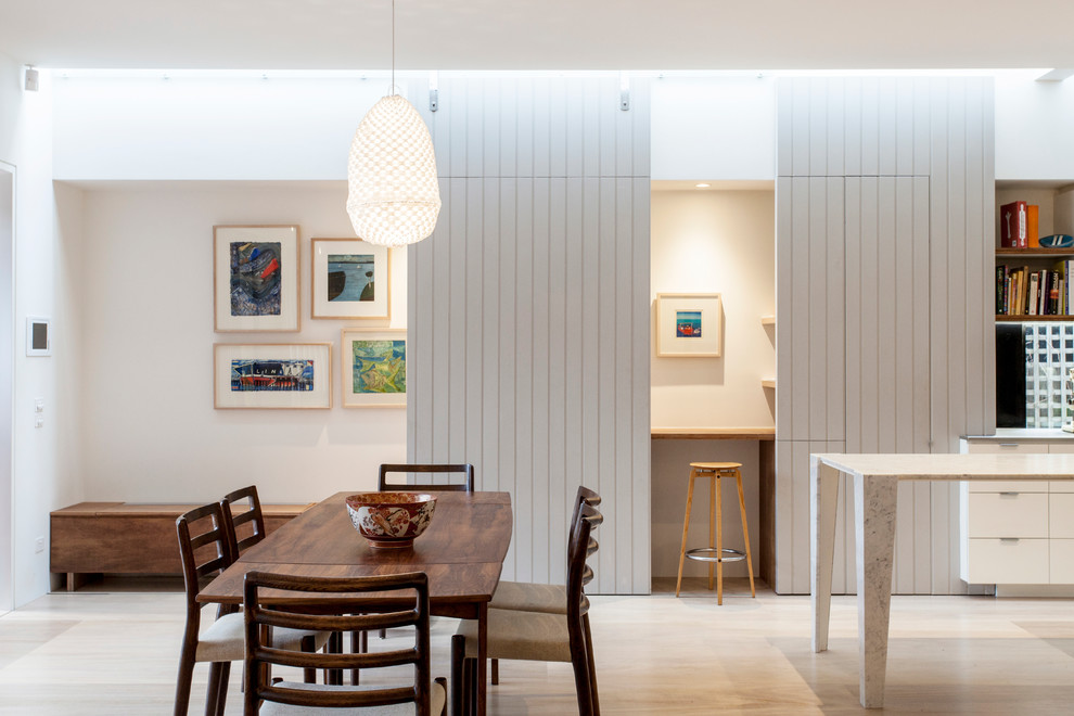 Idee per una sala da pranzo aperta verso la cucina minimal con pareti grigie e pavimento in compensato