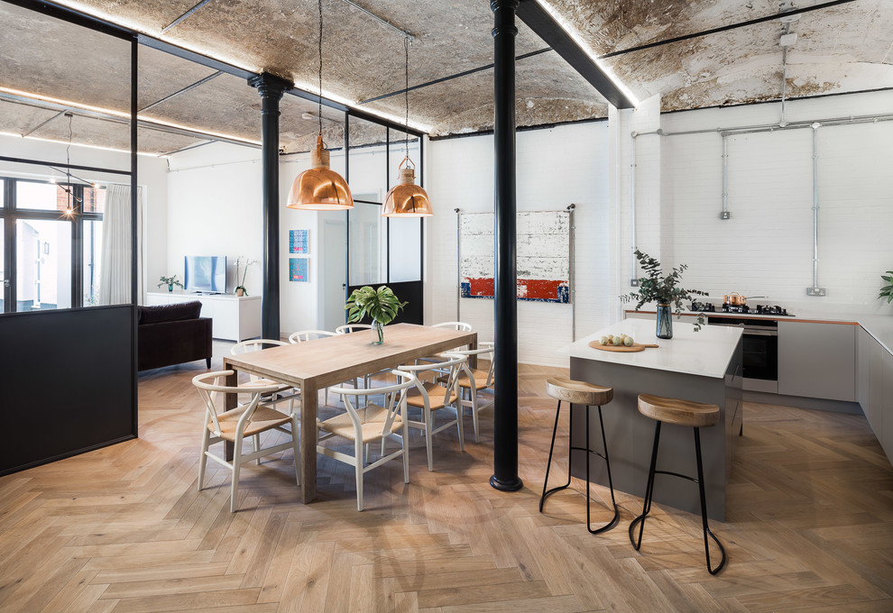 Industrial Wohnküche mit weißer Wandfarbe, braunem Holzboden und braunem Boden in London