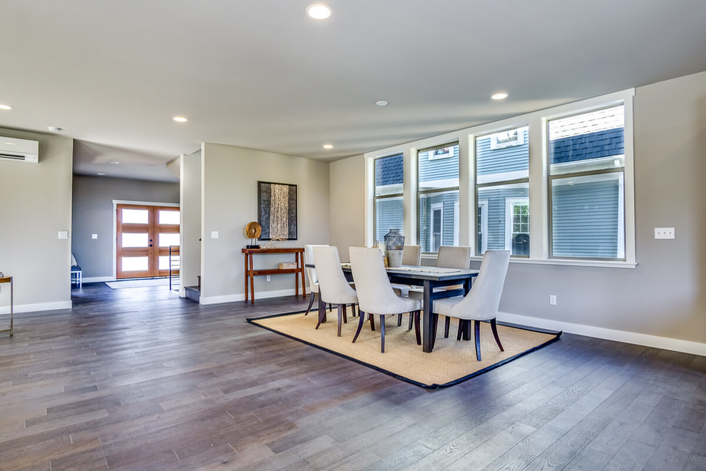 Immagine di un'ampia sala da pranzo aperta verso il soggiorno minimalista con pareti beige, parquet scuro e pavimento marrone