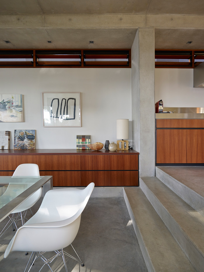 Immagine di una piccola sala da pranzo aperta verso il soggiorno contemporanea con pareti grigie, pavimento in cemento e pavimento grigio