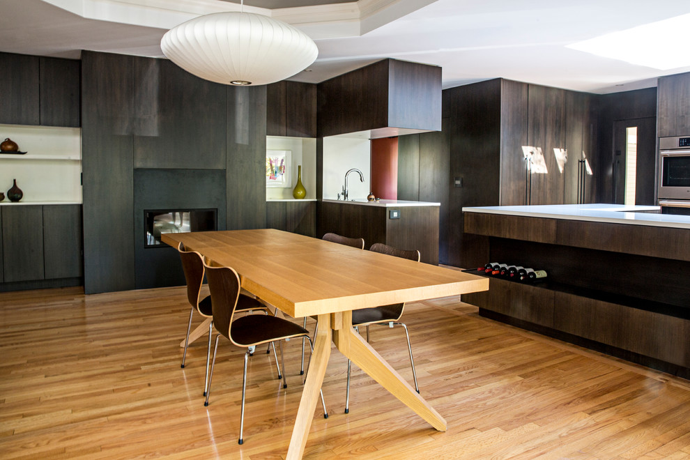 Пример оригинального дизайна: кухня-столовая среднего размера в стиле модернизм с разноцветными стенами, светлым паркетным полом, горизонтальным камином, фасадом камина из металла и коричневым полом