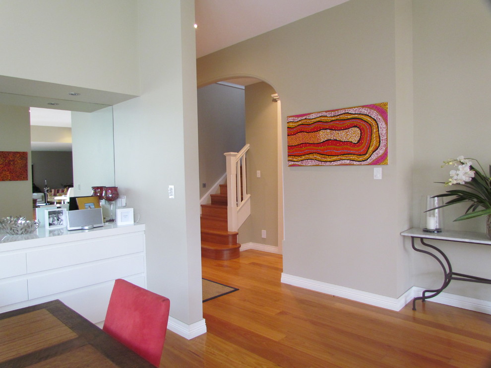 Esempio di una sala da pranzo aperta verso la cucina design di medie dimensioni con pareti beige e pavimento in legno massello medio