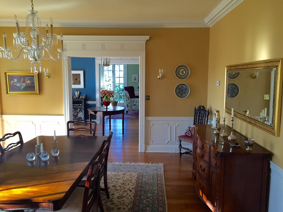 Foto di una sala da pranzo classica con pareti gialle e pavimento in legno massello medio