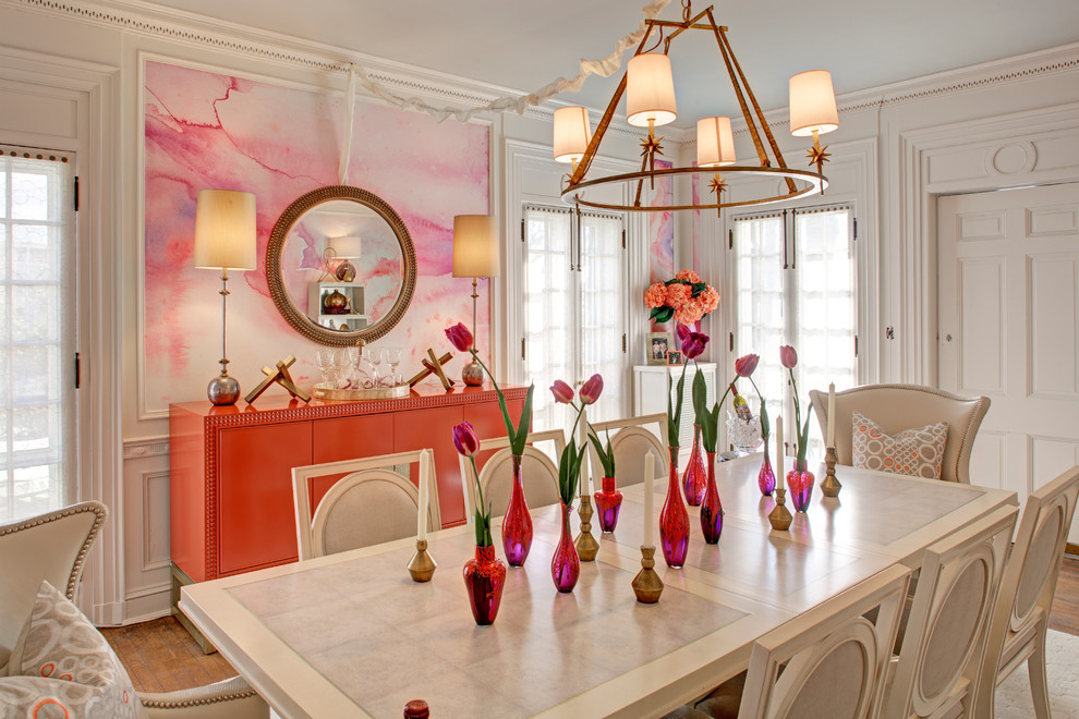 Cette image montre une salle à manger traditionnelle fermée avec un mur rose, un sol en bois brun et aucune cheminée.