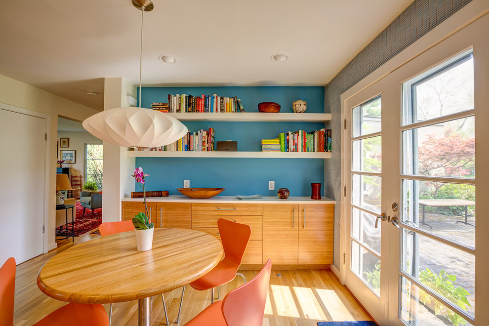 Inspiration pour une salle à manger design avec un mur bleu, un sol en bois brun et un sol marron.