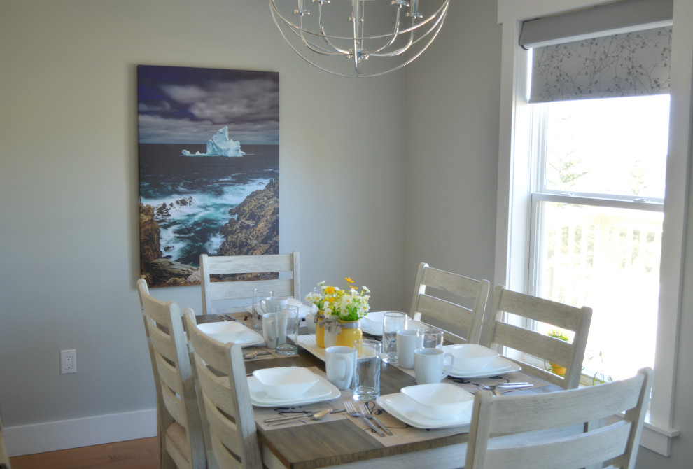 Exemple d'une salle à manger ouverte sur la cuisine bord de mer de taille moyenne avec un mur gris, parquet clair, un sol beige et un plafond voûté.