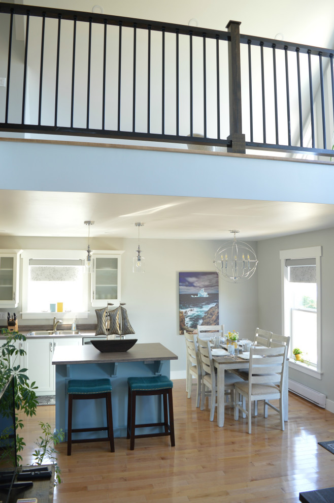 Foto di una sala da pranzo aperta verso la cucina stile marino di medie dimensioni con pareti grigie, parquet chiaro, pavimento beige e soffitto a volta