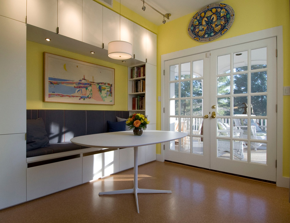 Immagine di una sala da pranzo aperta verso la cucina moderna con pareti gialle