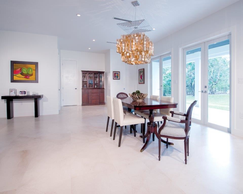 Immagine di una sala da pranzo aperta verso il soggiorno tradizionale di medie dimensioni con pareti bianche, pavimento in pietra calcarea e pavimento bianco