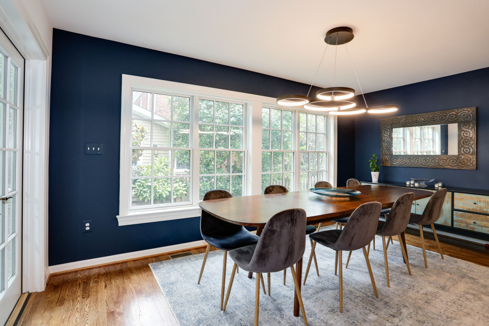 Foto di una sala da pranzo aperta verso il soggiorno tradizionale di medie dimensioni con pareti blu, pavimento in legno massello medio, pavimento marrone e pareti in mattoni