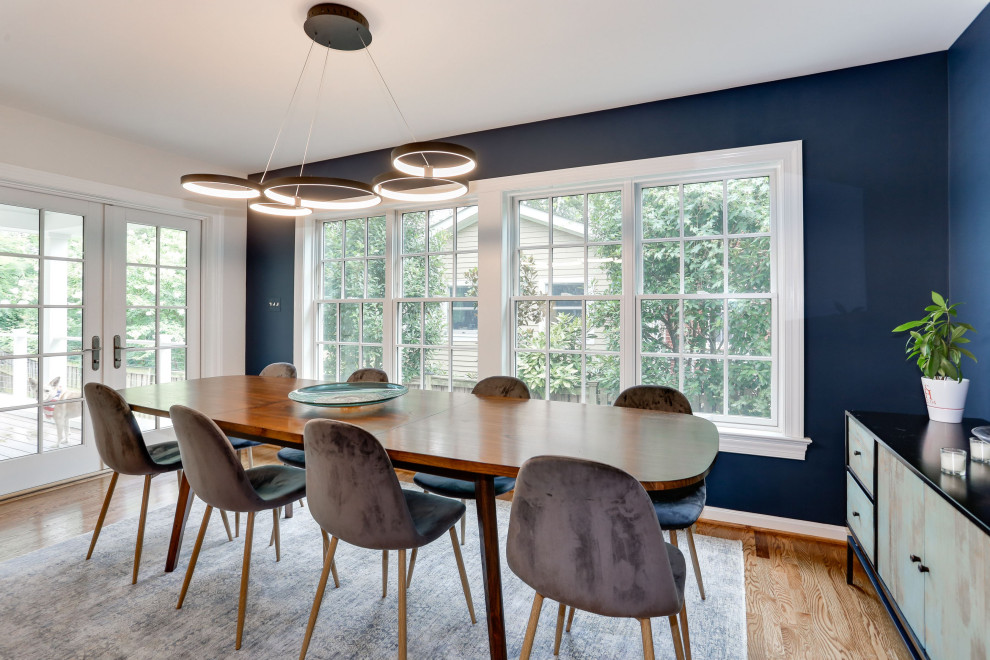 Ispirazione per una sala da pranzo aperta verso il soggiorno tradizionale di medie dimensioni con pareti blu, pavimento in legno massello medio, pavimento marrone e pareti in mattoni