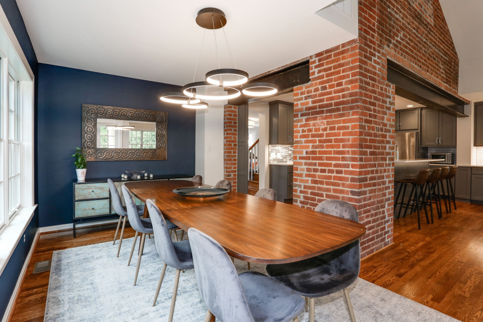 Inspiration pour une salle à manger ouverte sur le salon traditionnelle de taille moyenne avec un mur bleu, un sol en bois brun, un sol marron et un mur en parement de brique.