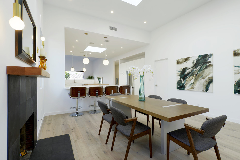 Свежая идея для дизайна: кухня-столовая в современном стиле с белыми стенами, светлым паркетным полом, стандартным камином и бежевым полом - отличное фото интерьера