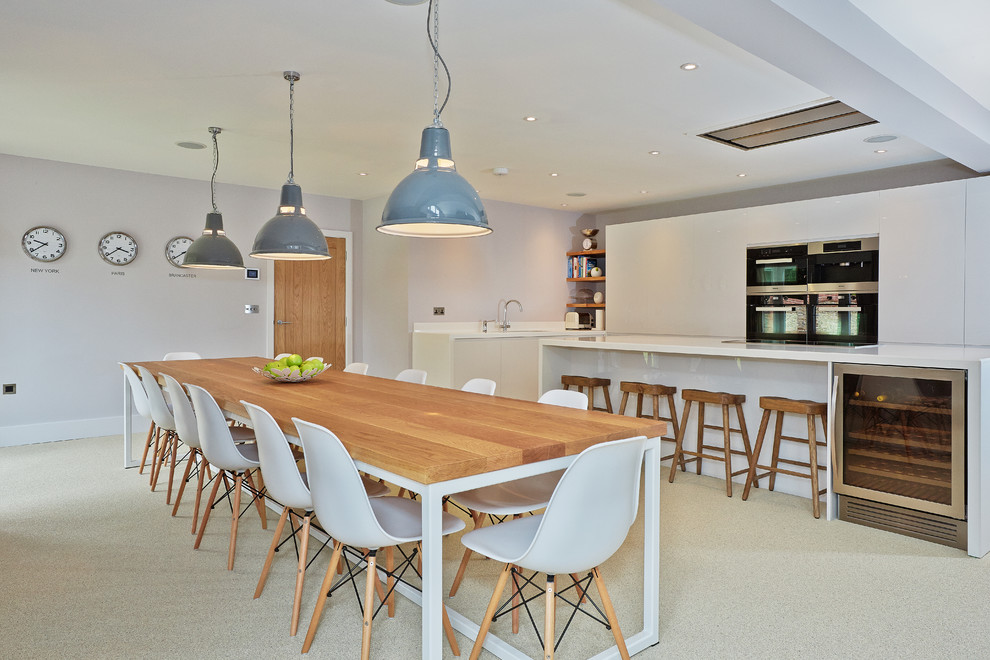 Foto di una sala da pranzo aperta verso la cucina design con pareti grigie