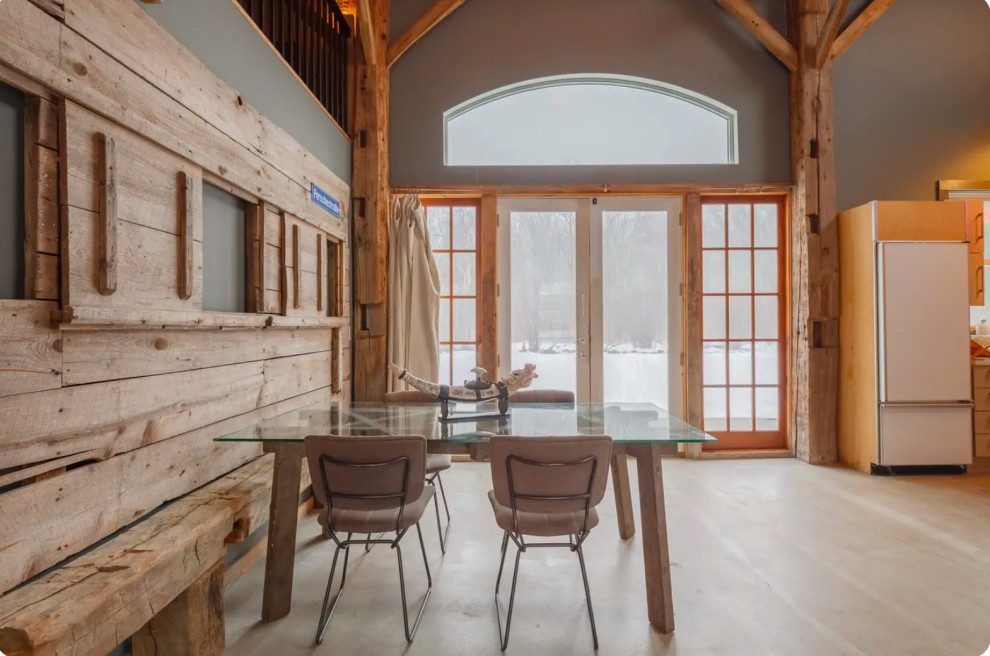 Cette photo montre une salle à manger ouverte sur la cuisine industrielle en bois avec sol en béton ciré, un sol gris et un plafond en bois.