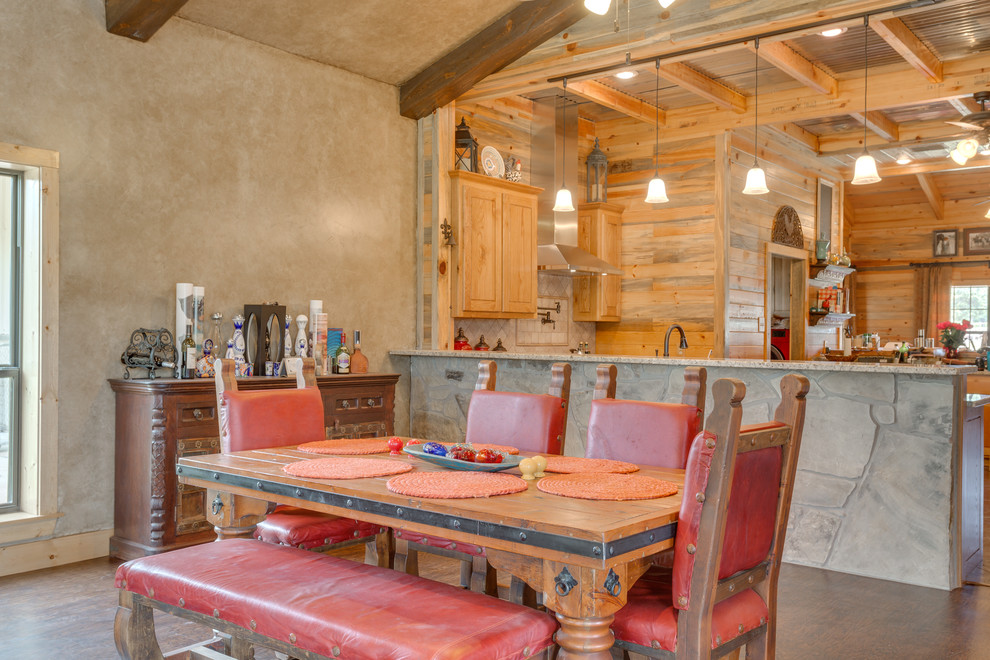 This is an example of a medium sized rustic open plan dining room in Dallas with beige walls, vinyl flooring, a standard fireplace, a stone fireplace surround and brown floors.