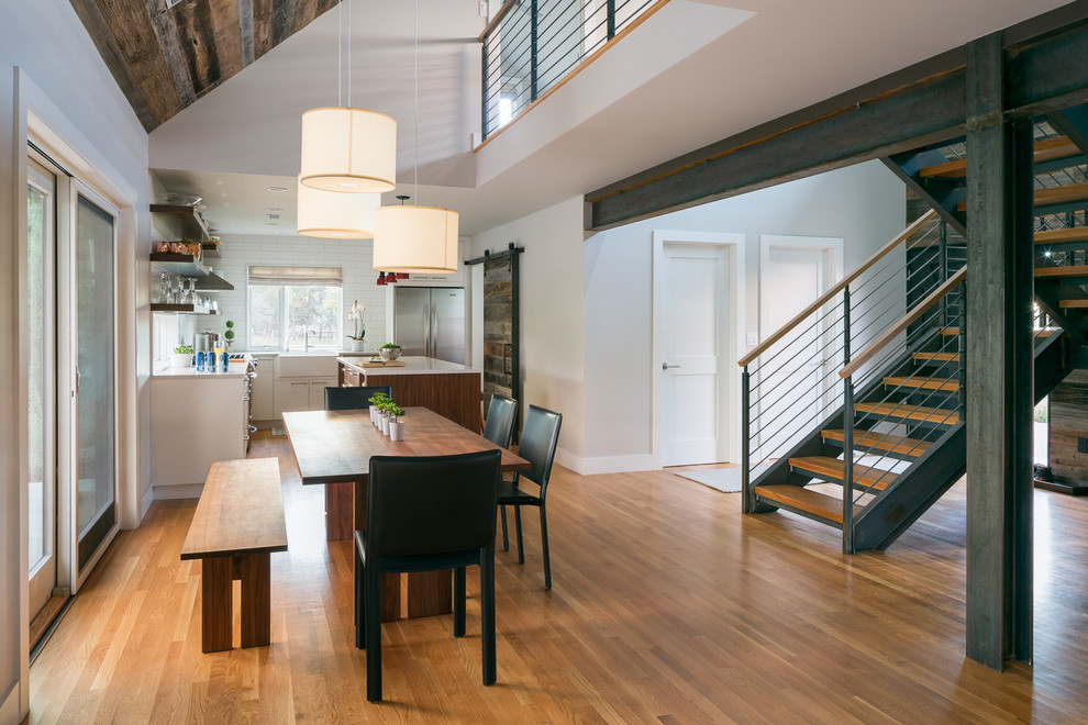 Mittelgroße Landhausstil Wohnküche mit weißer Wandfarbe, hellem Holzboden und schwarzem Boden in Denver