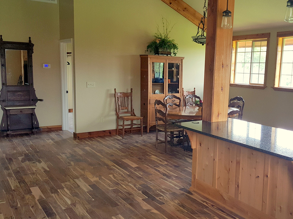 Foto di una sala da pranzo aperta verso la cucina country di medie dimensioni con pareti bianche, pavimento in legno massello medio, pavimento marrone e nessun camino