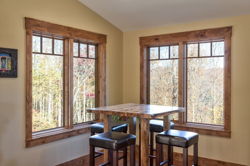 Inspiration pour une salle à manger ouverte sur la cuisine craftsman de taille moyenne avec un mur beige, parquet foncé et un sol marron.