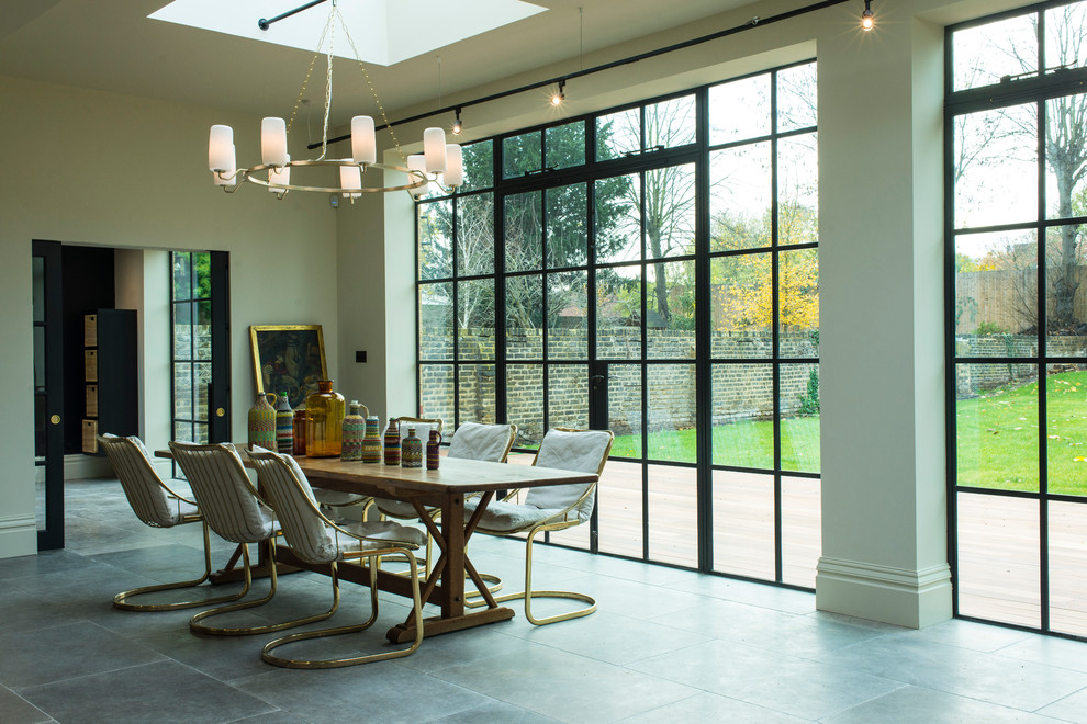 Ispirazione per una grande sala da pranzo aperta verso il soggiorno minimalista con pareti bianche e pavimento grigio