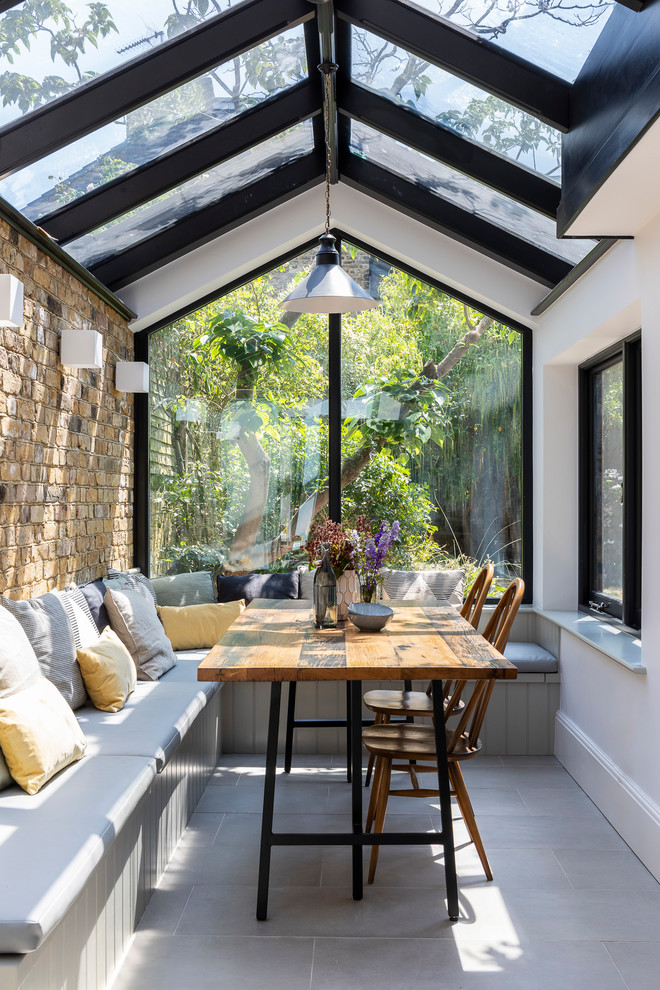 Example of a mid-sized transitional gray floor kitchen/dining room combo design in London with white walls