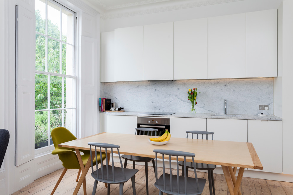 Inspiration för minimalistiska kök med matplatser, med vita väggar och ljust trägolv